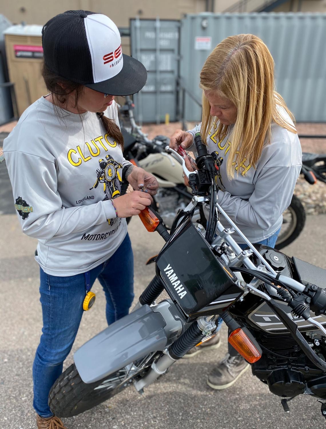 Piper and one of her employees do some maintenance on one of her school’s motorcycles.